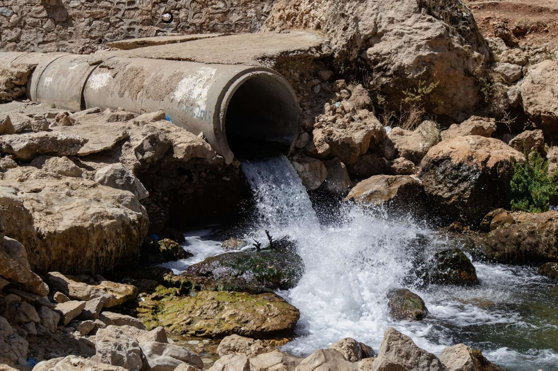 A culvert discharging clean into a rocky stream