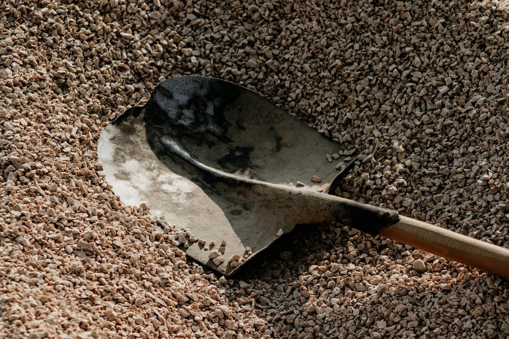A shovel resting in crushed gravel